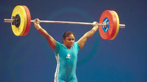 Karnam Malleswari, India's first female Olympic medalist, lifting weights during a competition, showcasing determination and strength.